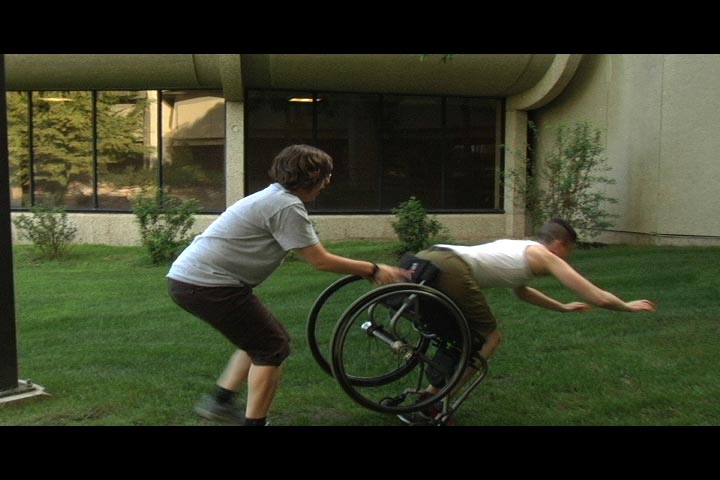 Movie still of D being dumped our of her wheelchair by 